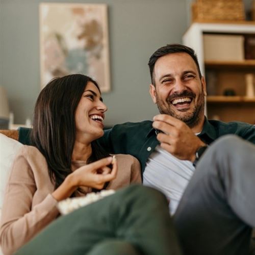 Happy couple laughing on sofa