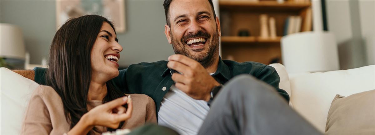 Couple laughing on sofa
