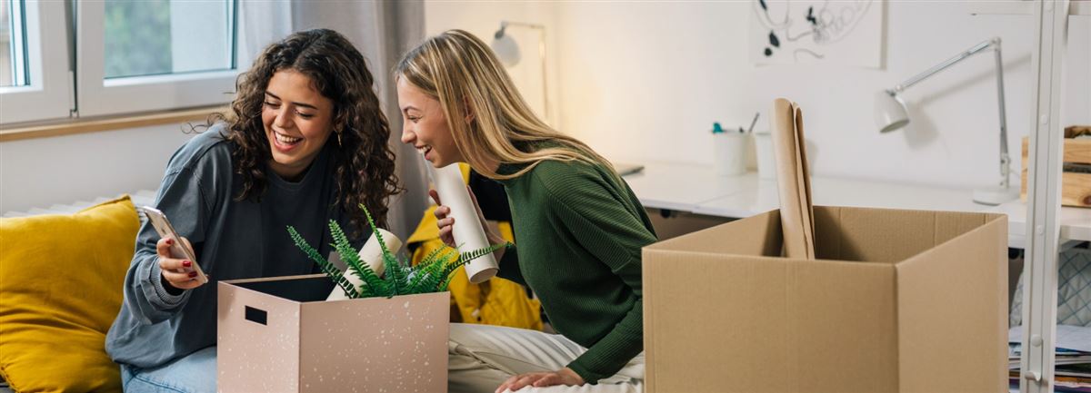 Students moving-in smiling look at a phone