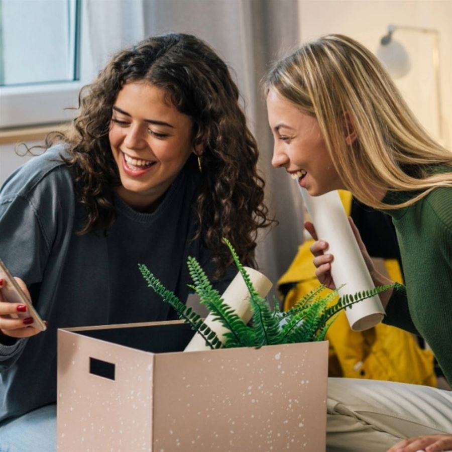 Students moving-in smiling look at a phone