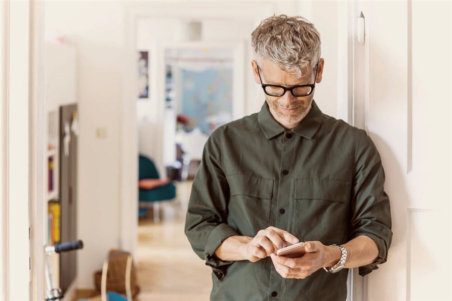 Man at home holding mobile phone