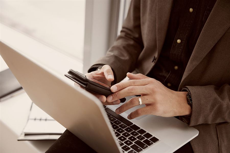 Closeup of man using a mobile and laptop