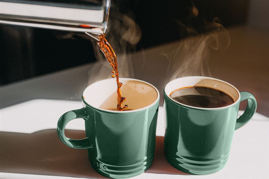 Two green cups of black coffee