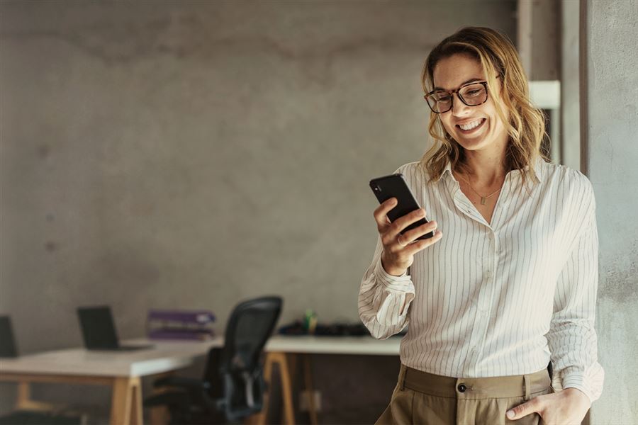Woman smiling while looking at mobile phone
