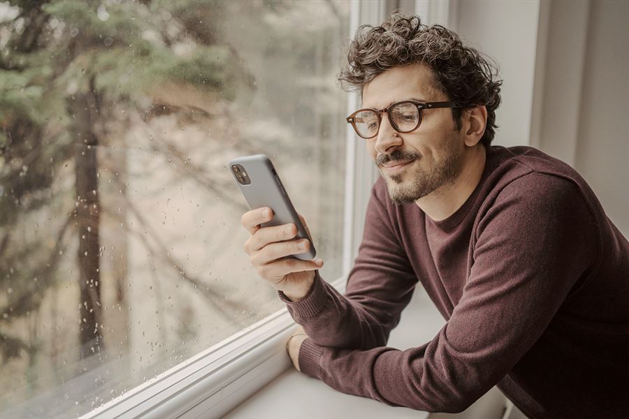 Man with glasses looking at mobile phone