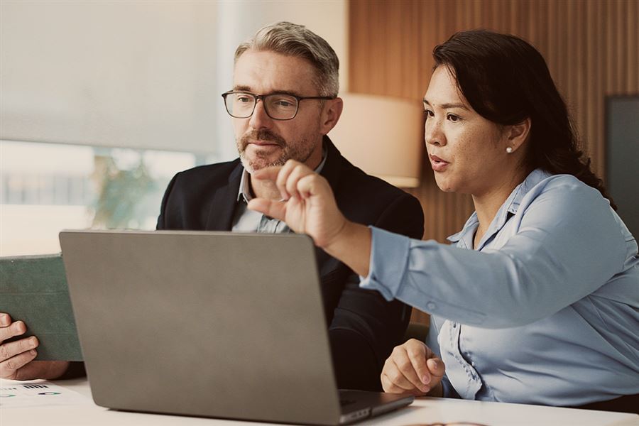 Man and woman looking at laptop and tablet