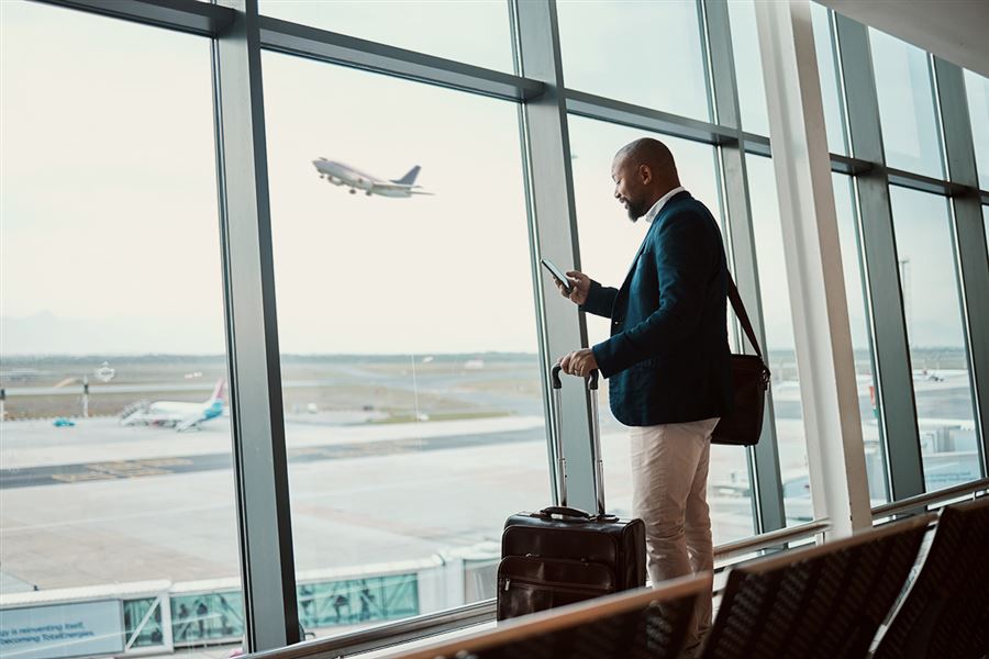 Man in airport looking at mobile phone
