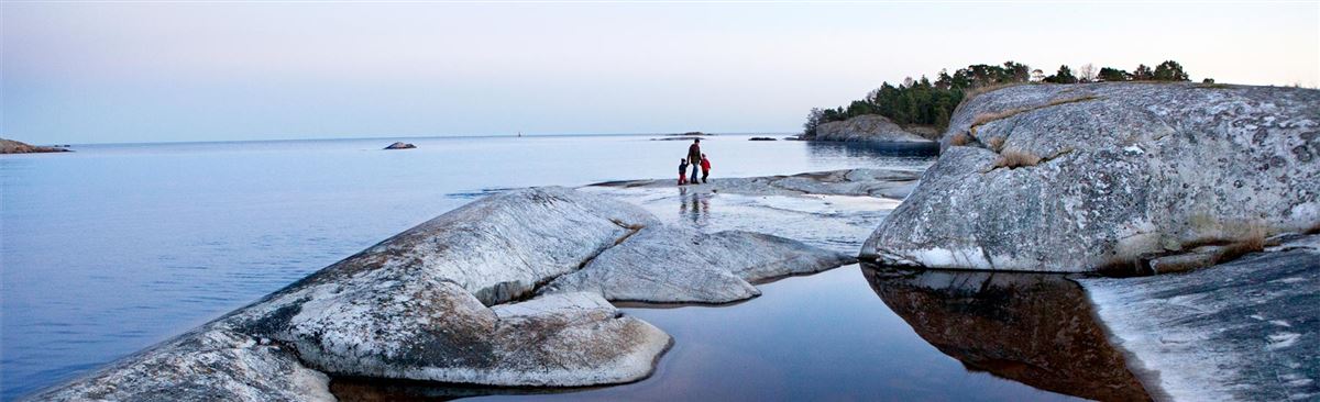 A family on rocks by the water